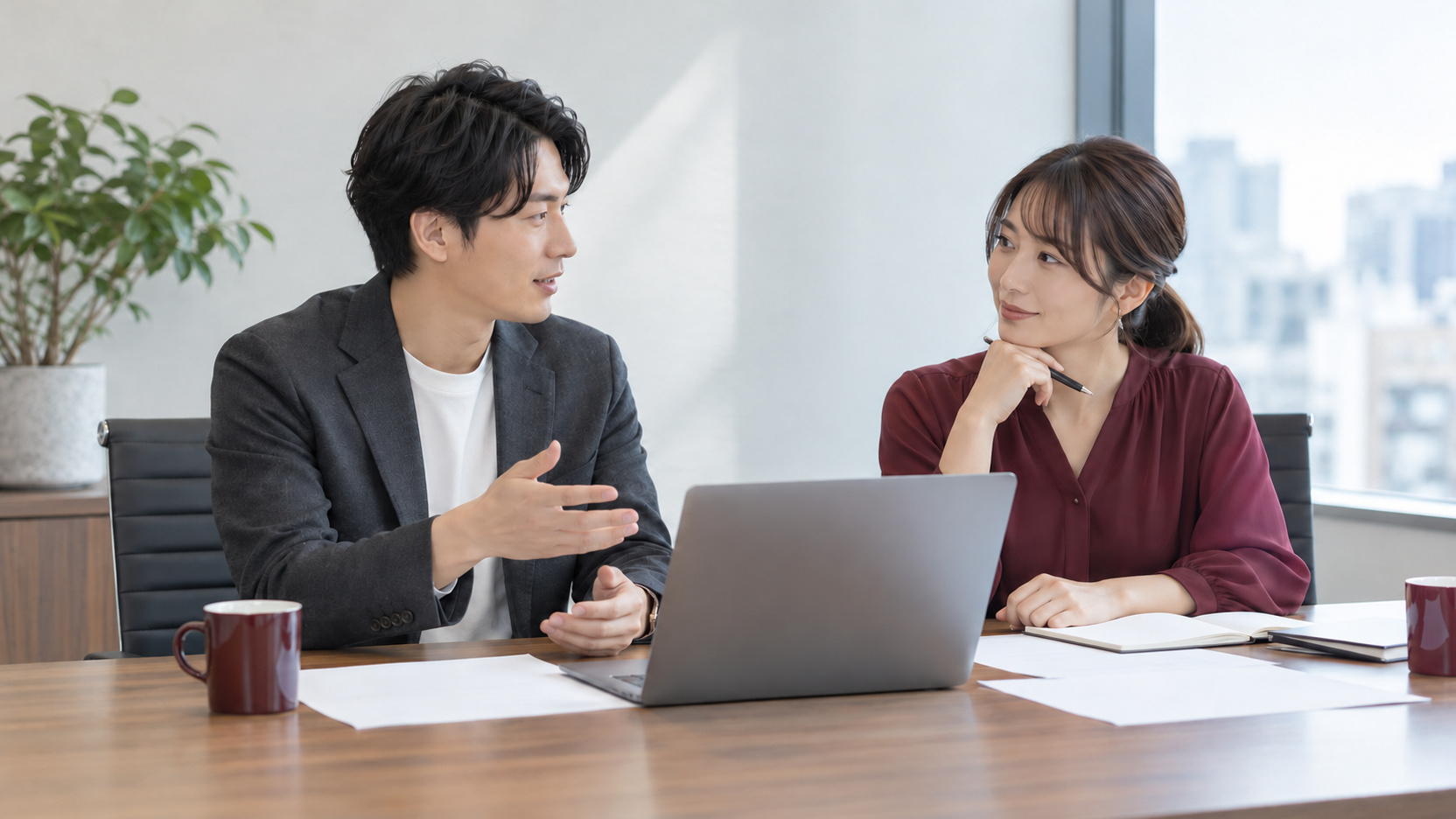 自社担当者と外部ライターが資料とノートPCを囲み、記事制作の依頼範囲を相談する